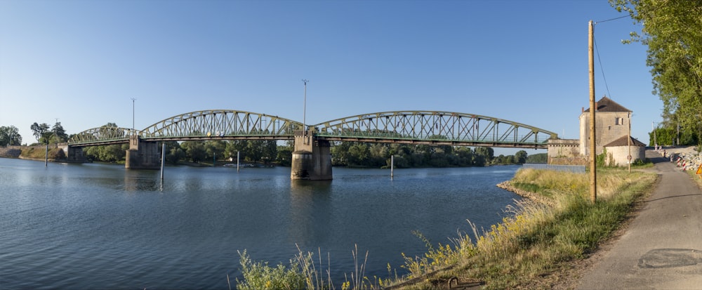 a bridge over a river with a tower in the background