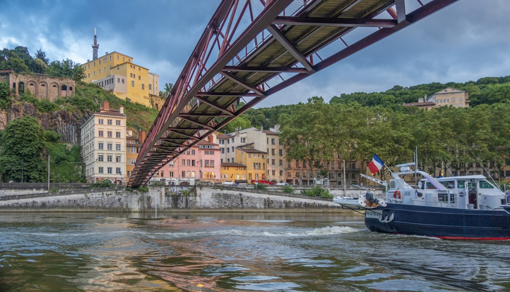 a boat traveling under a bridge on a river