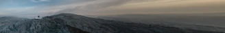 A panoramic shot capturing the foggy landscape and farmhouse plots of Gorthan at dawn.