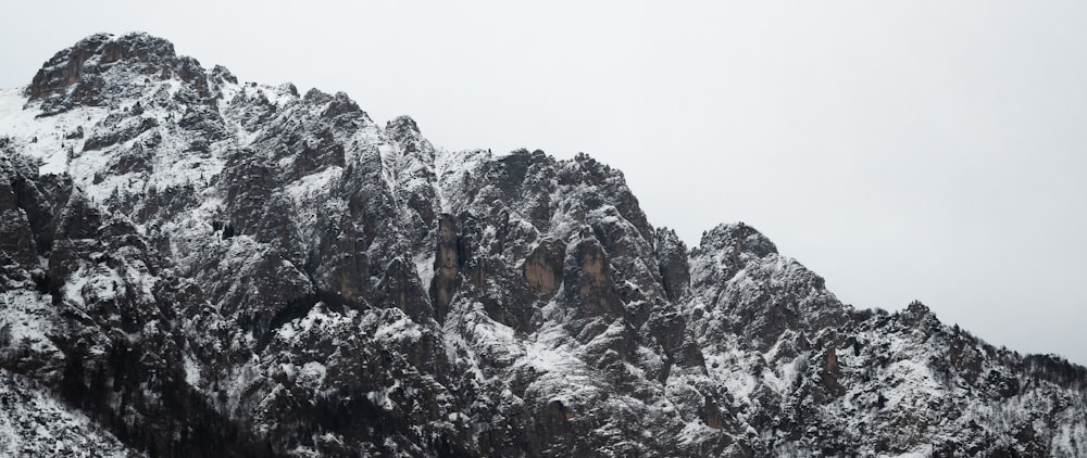 a mountain covered in snow with a sky background