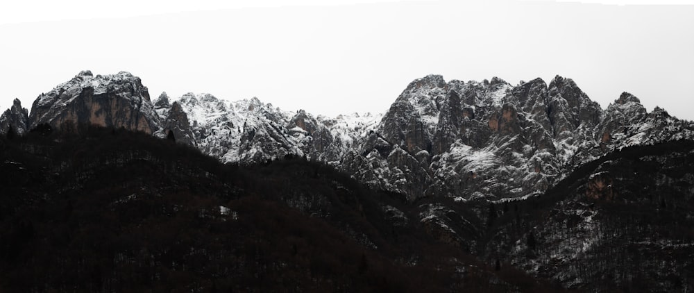 a mountain range covered in snow with mountains in the background