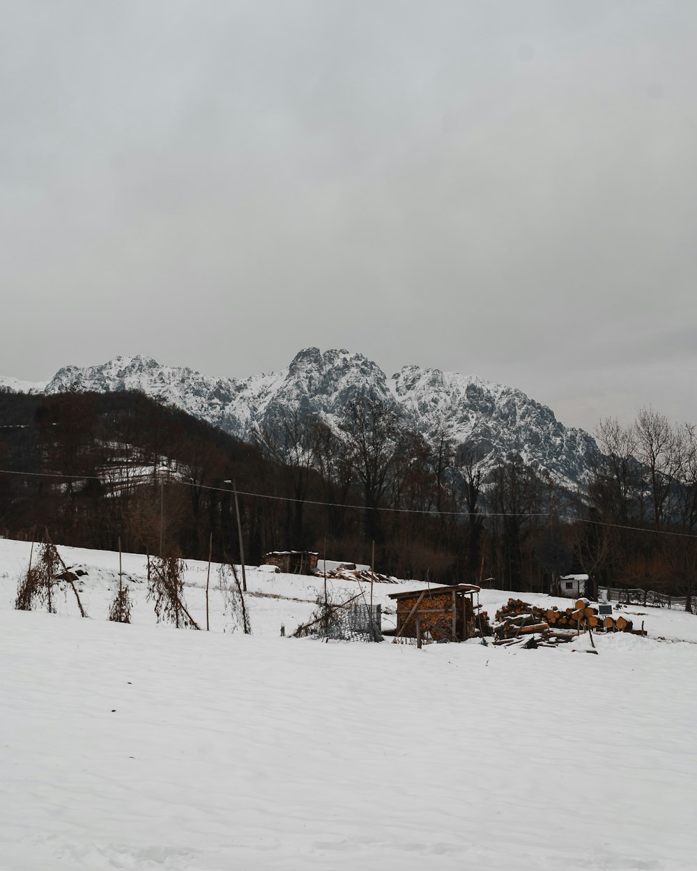 a snow covered field with mountains in the background