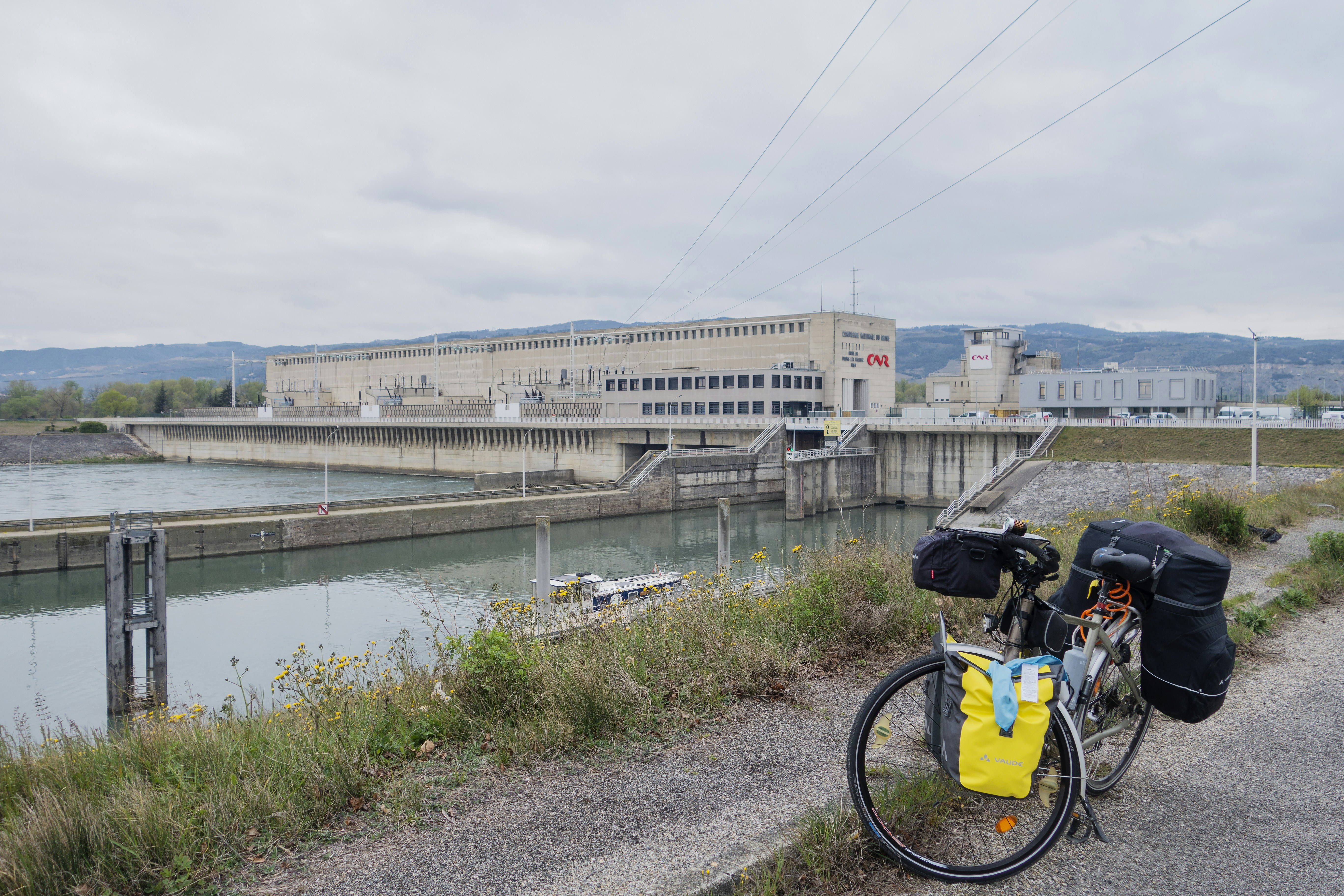 a bicycle parked on the side of a road next to a river