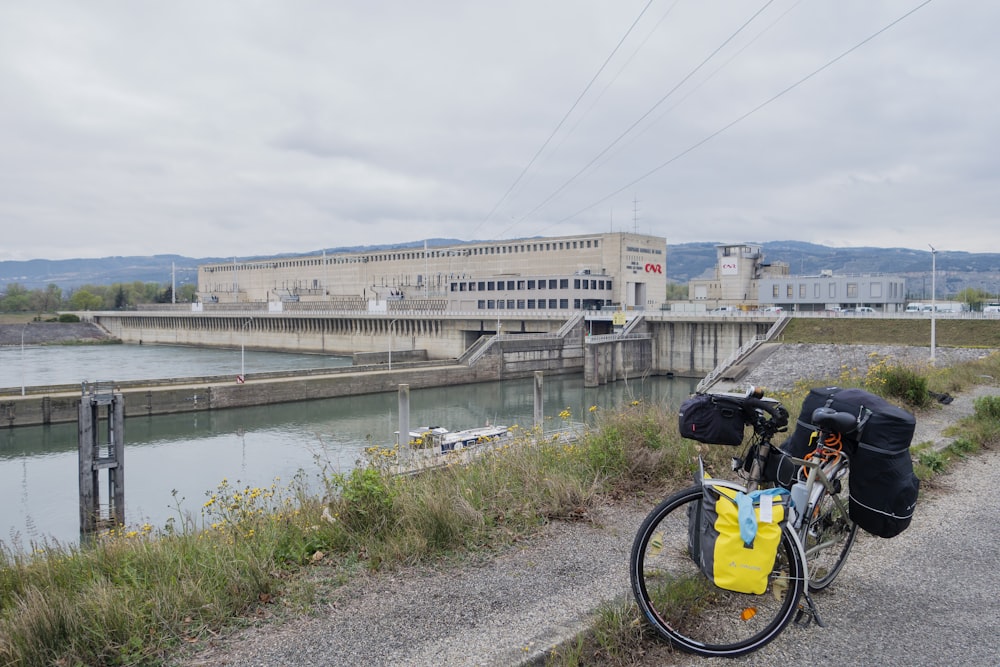 a bicycle parked on the side of a road next to a river