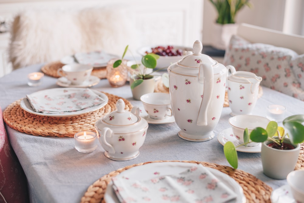 a table set for a tea party with flowers on it