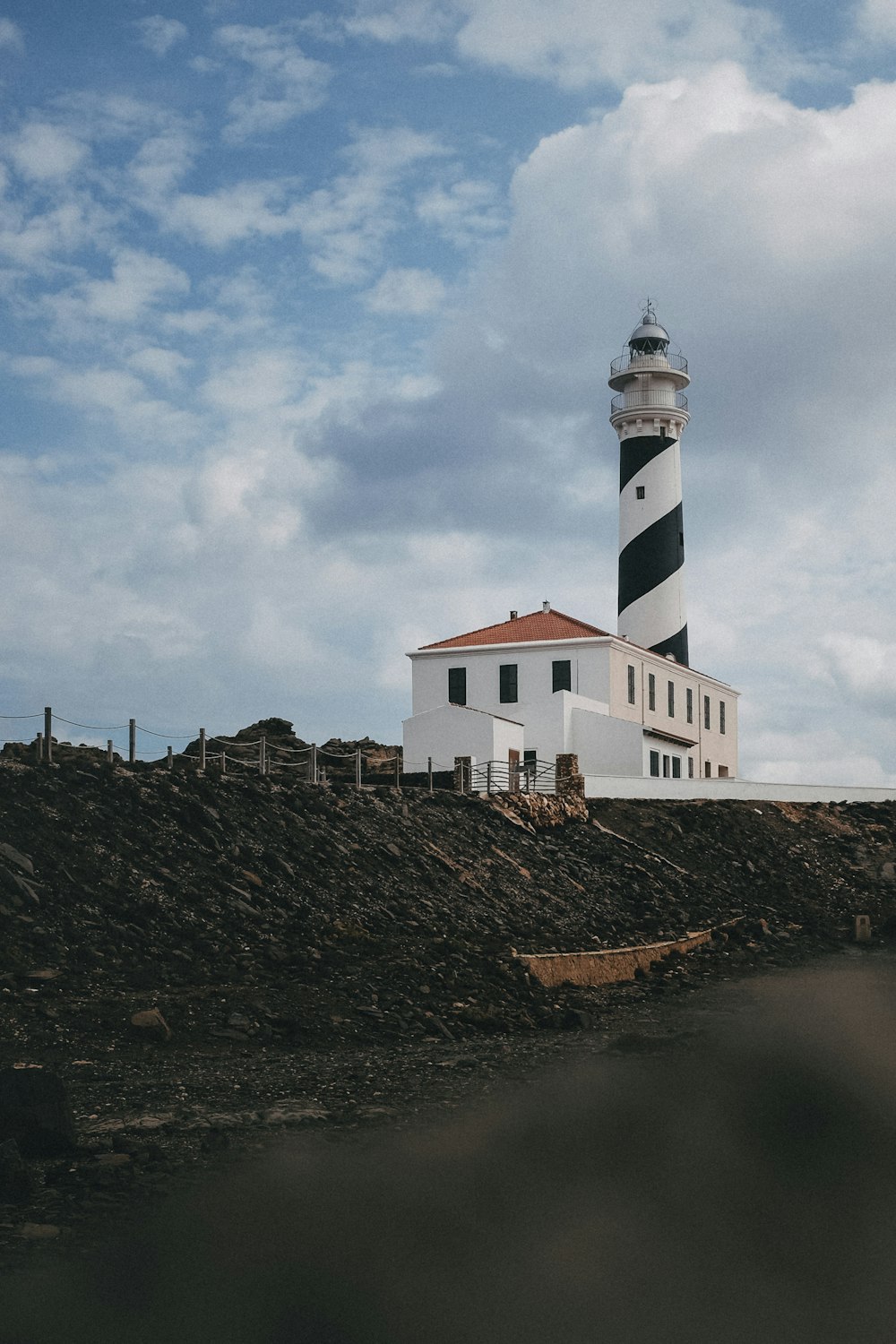 a lighthouse on top of a hill with a sky background