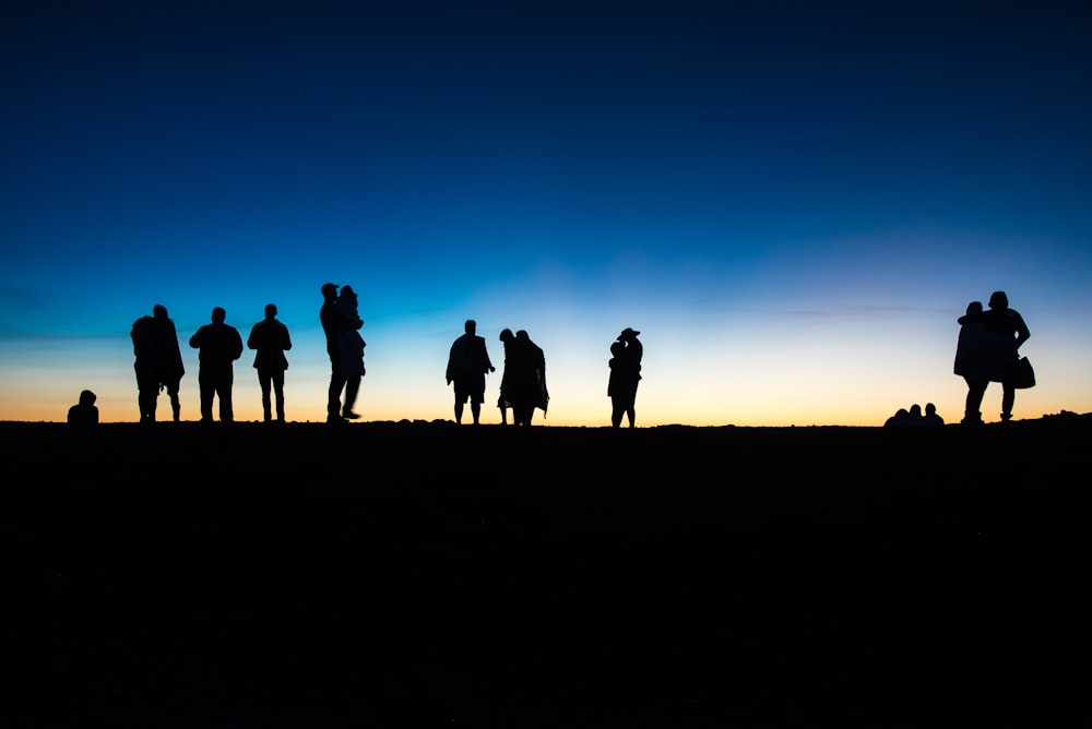 un groupe de personnes debout au sommet d’une colline