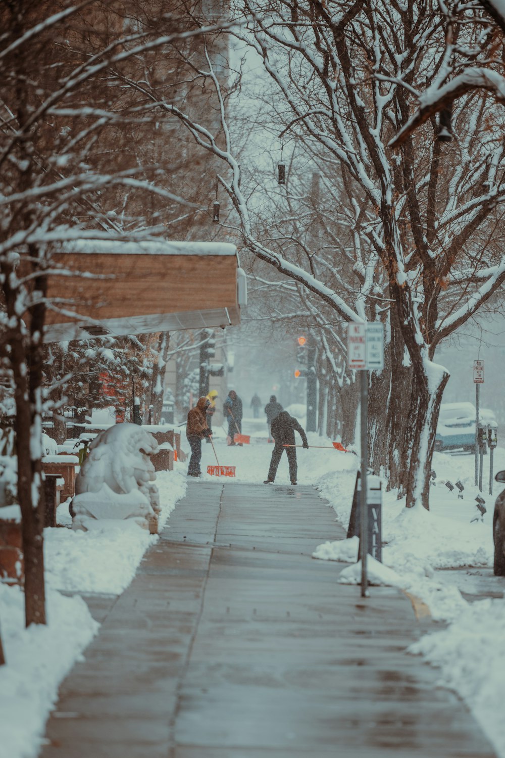 a group of people walking down a snow covered sidewalk