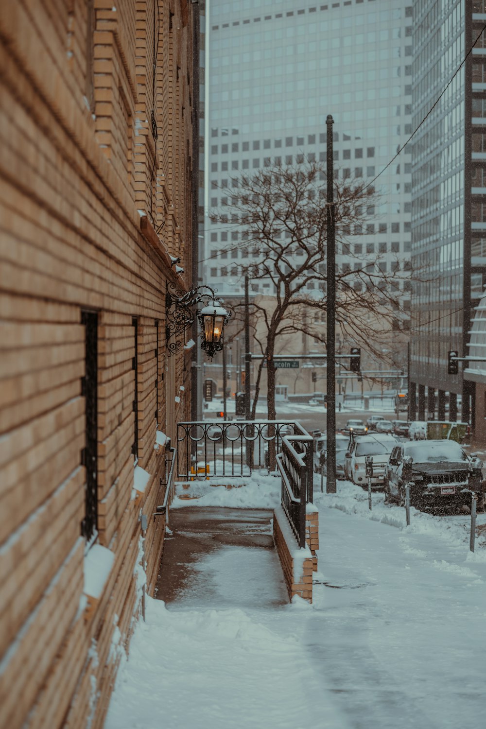 a snow covered sidewalk next to a brick building