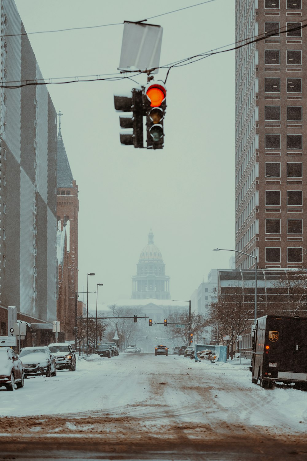 a traffic light hanging over a snow covered street