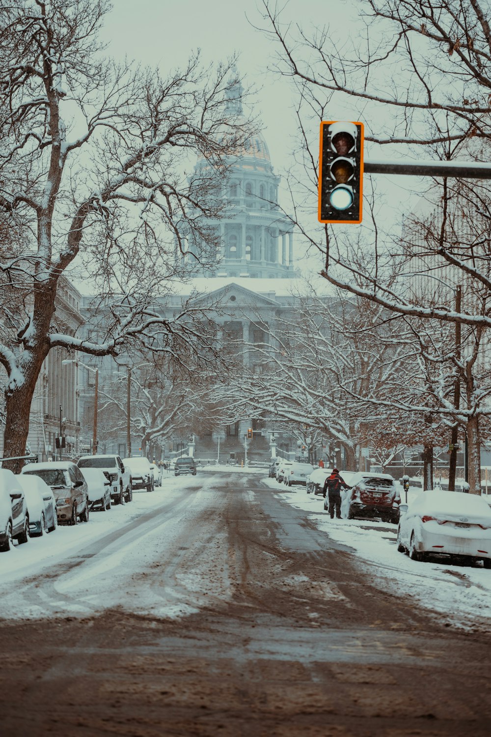 a traffic light hanging over a snowy street