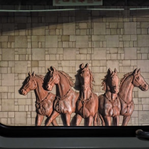 a group of horses standing next to a brick wall