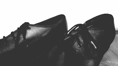 a pair of black shoes sitting on top of a wooden floor