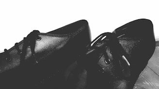 a pair of black shoes sitting on top of a wooden floor