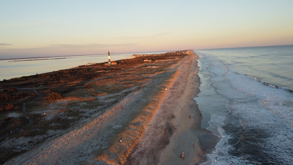 an aerial view of a beach with a lighthouse in the distance