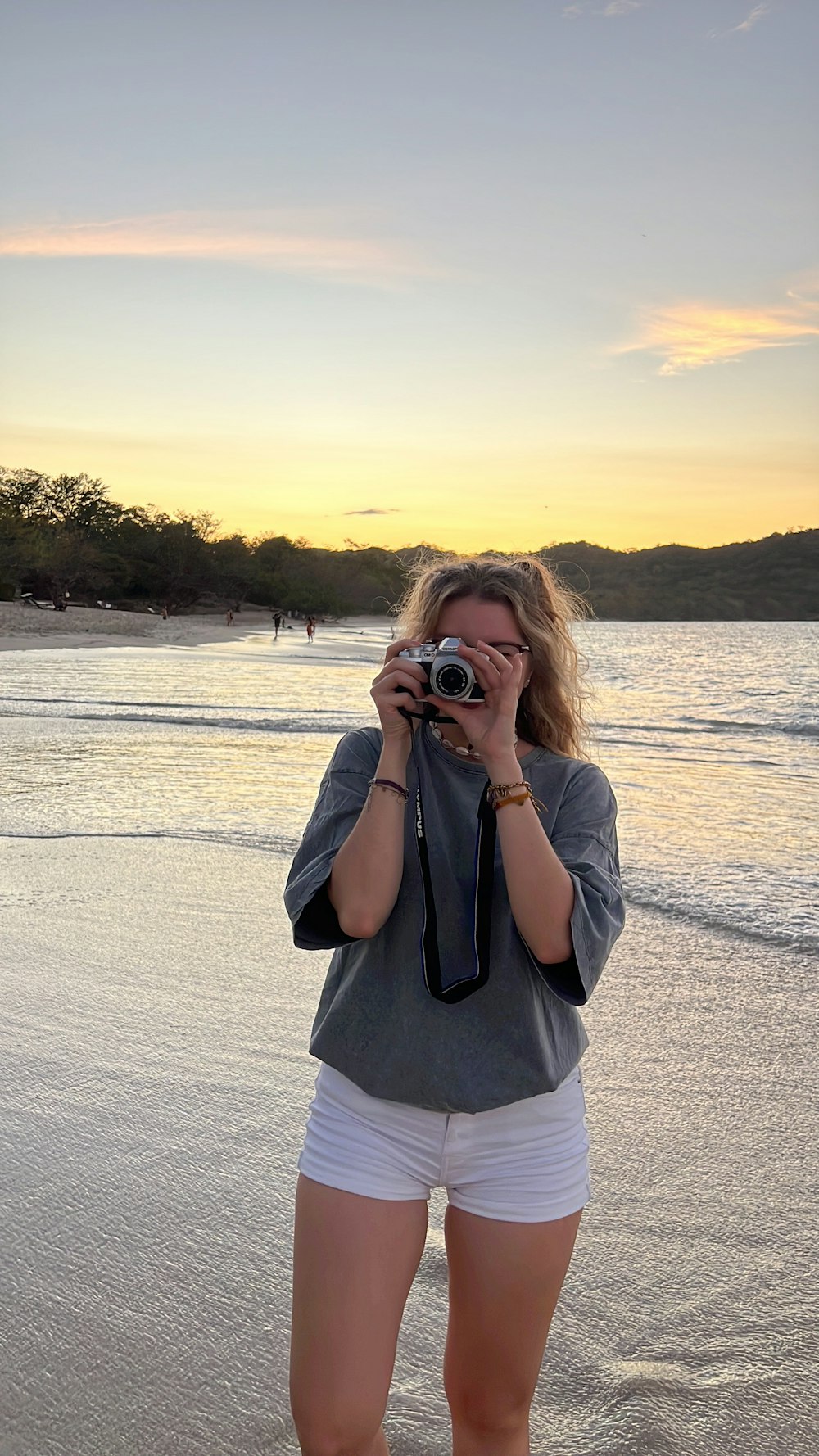 uma mulher tirando uma foto de si mesma na praia