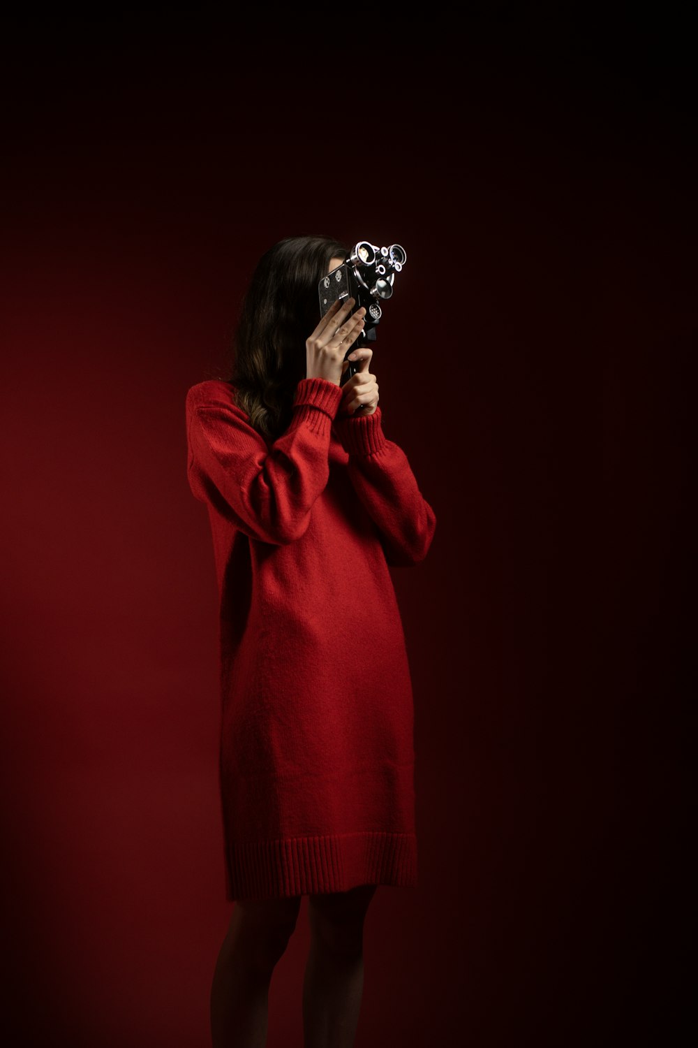 a woman in a red dress holding a camera