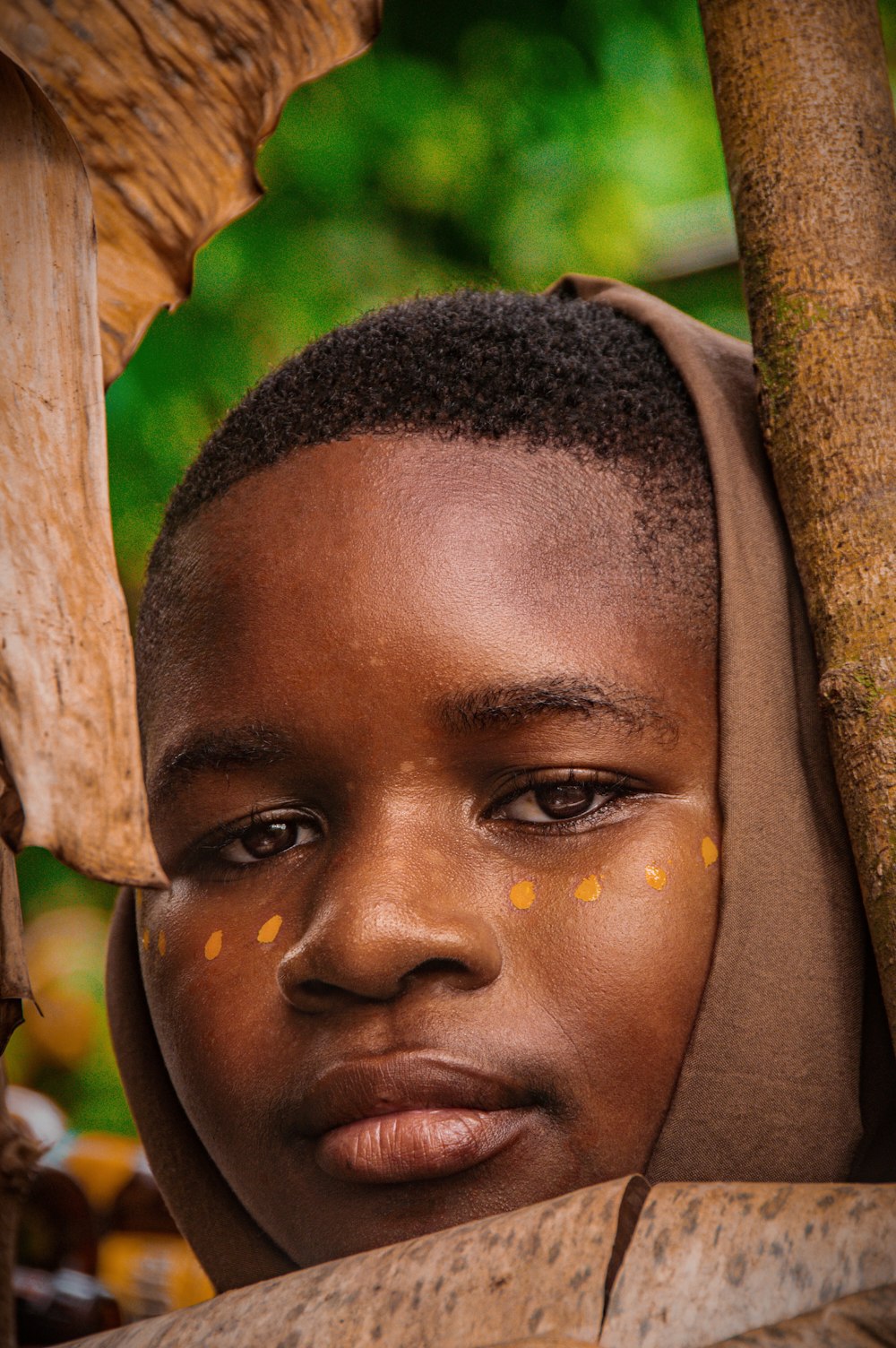 a young boy wearing a brown head scarf