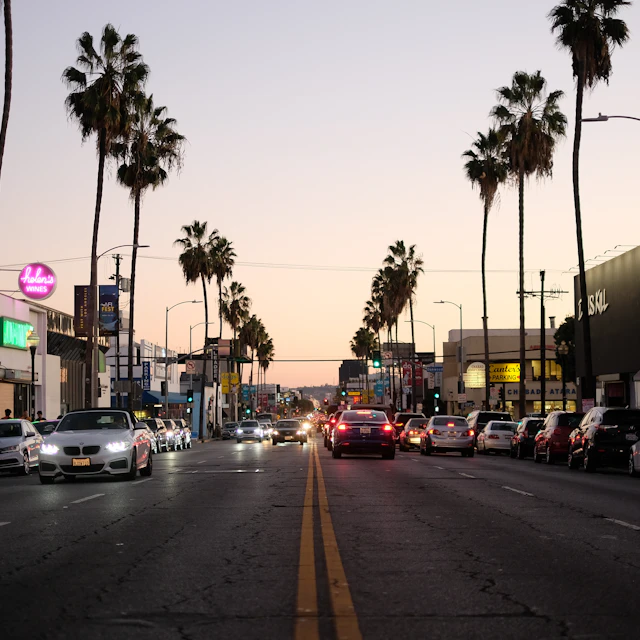 A Los Angeles street filled with traffic next to tall palm trees