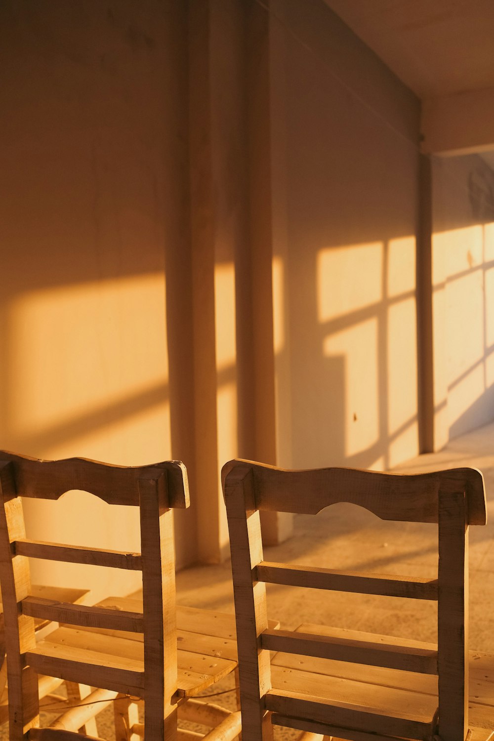 a couple of wooden chairs sitting on top of a hard wood floor