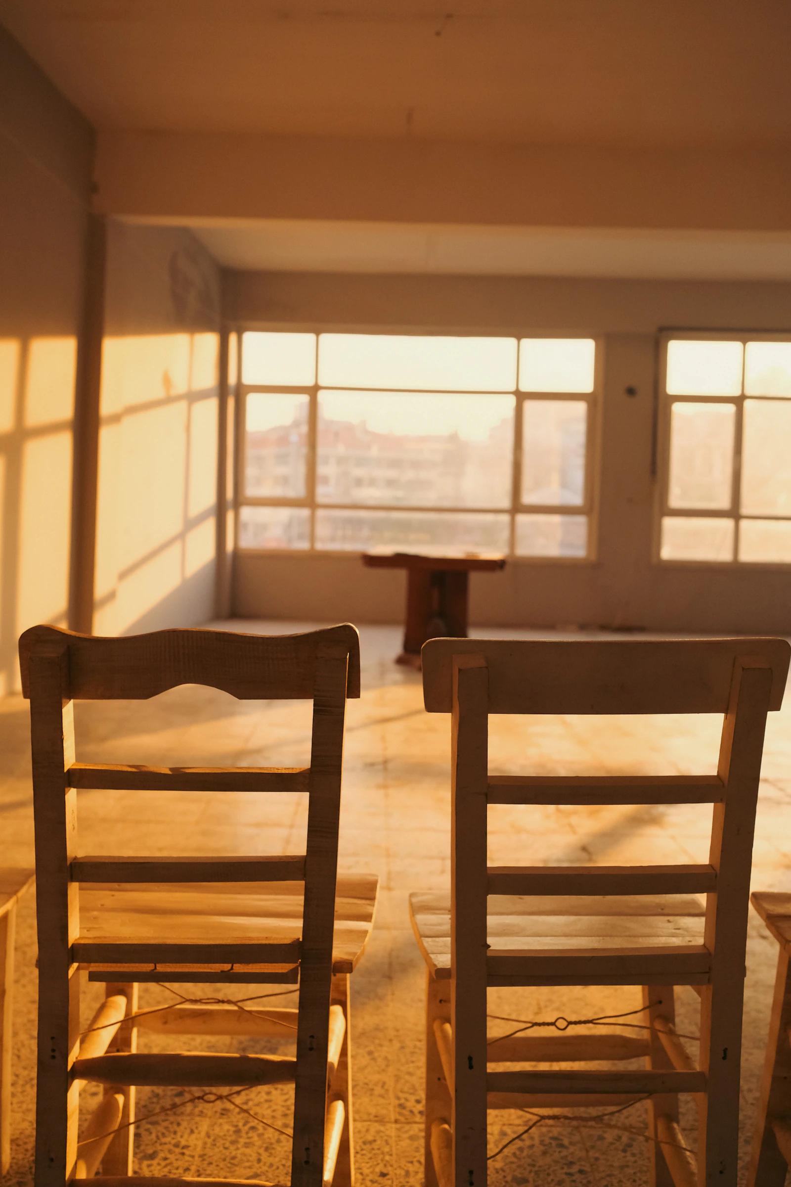 Two wooden chairs side by side in a room filled with warm afternoon light