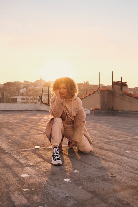 A stylish urban outfit displayed on a city rooftop at sunset.