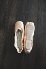a pair of ballet shoes sitting on top of a wooden floor