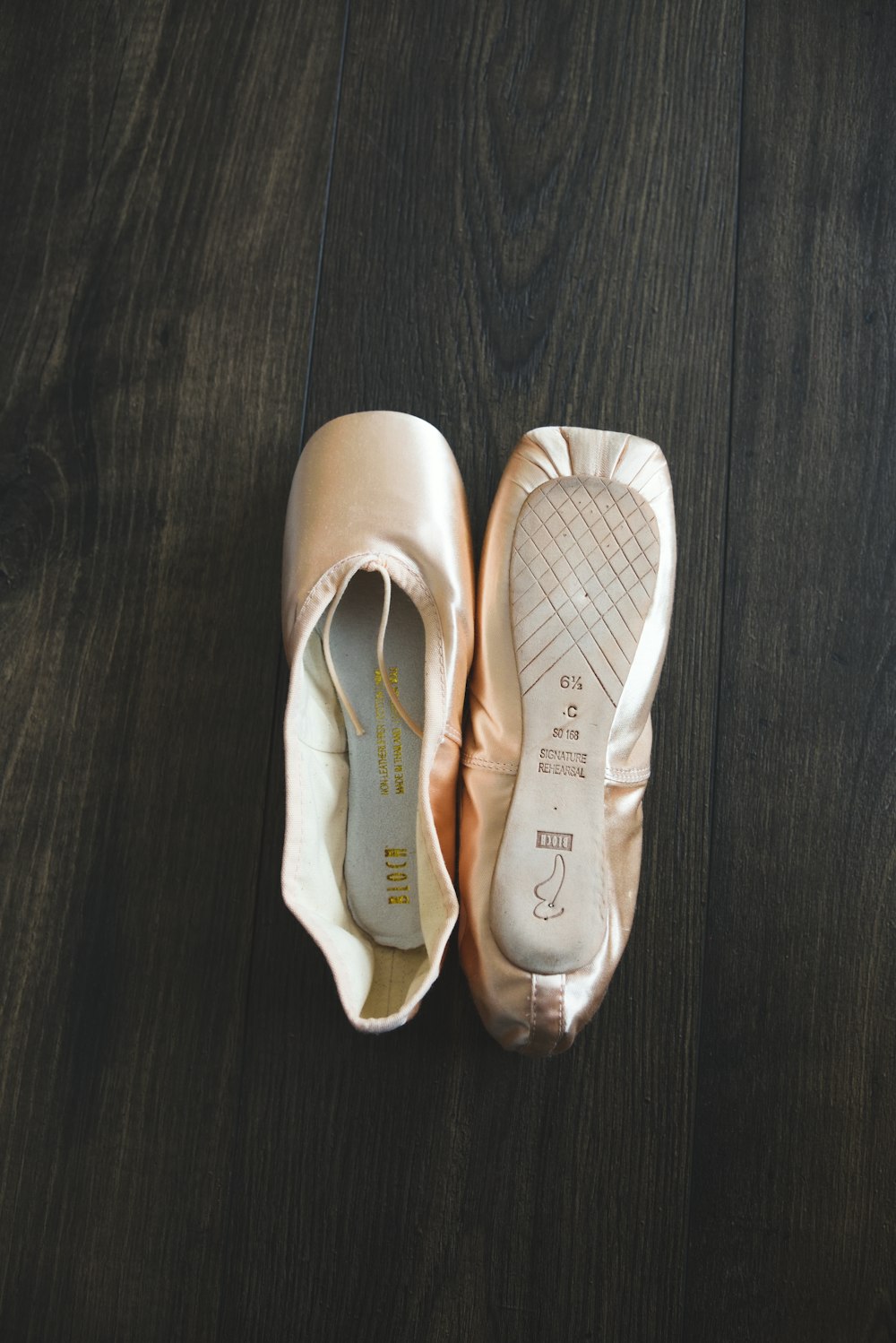 a pair of ballet shoes sitting on top of a wooden floor