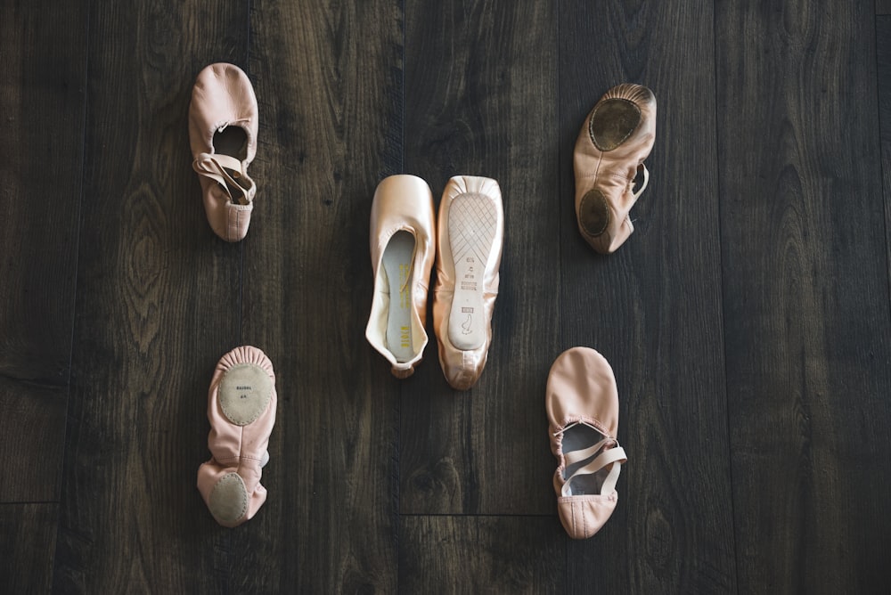 a group of ballet shoes sitting on top of a wooden floor