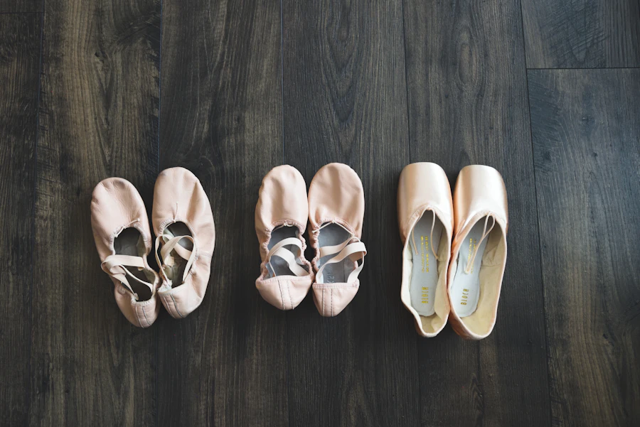 Ballet slippers and pointe shoes lined up on a wood floor