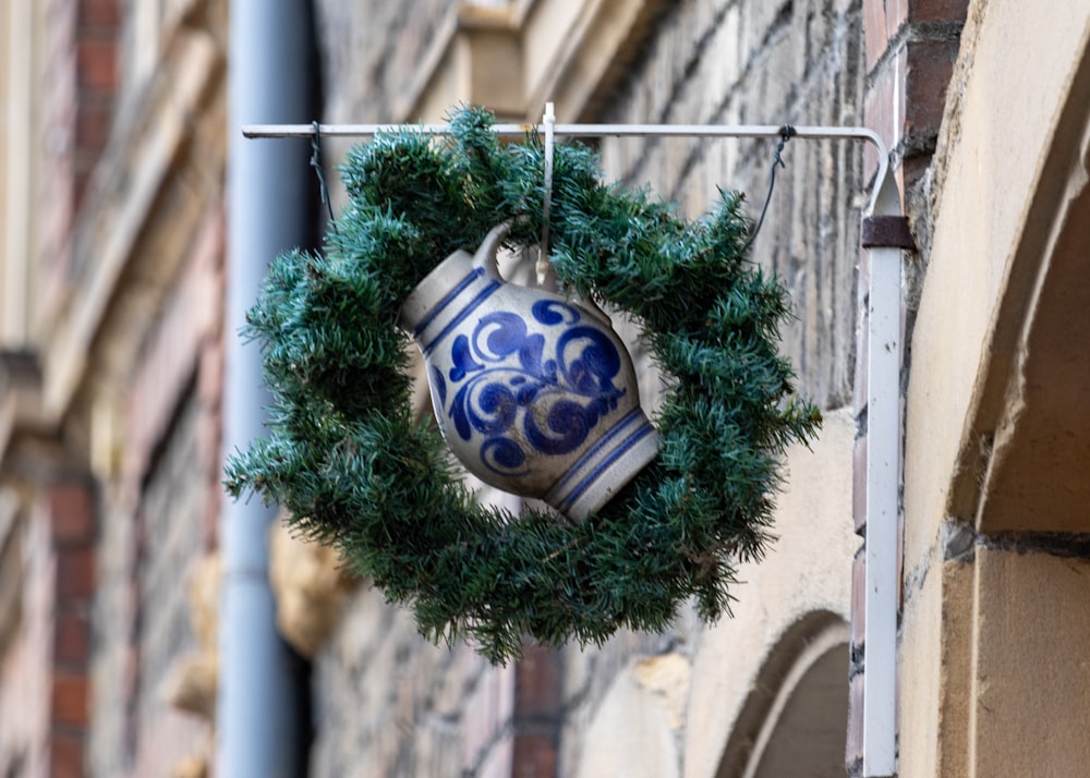 a blue and white vase hanging from the side of a building