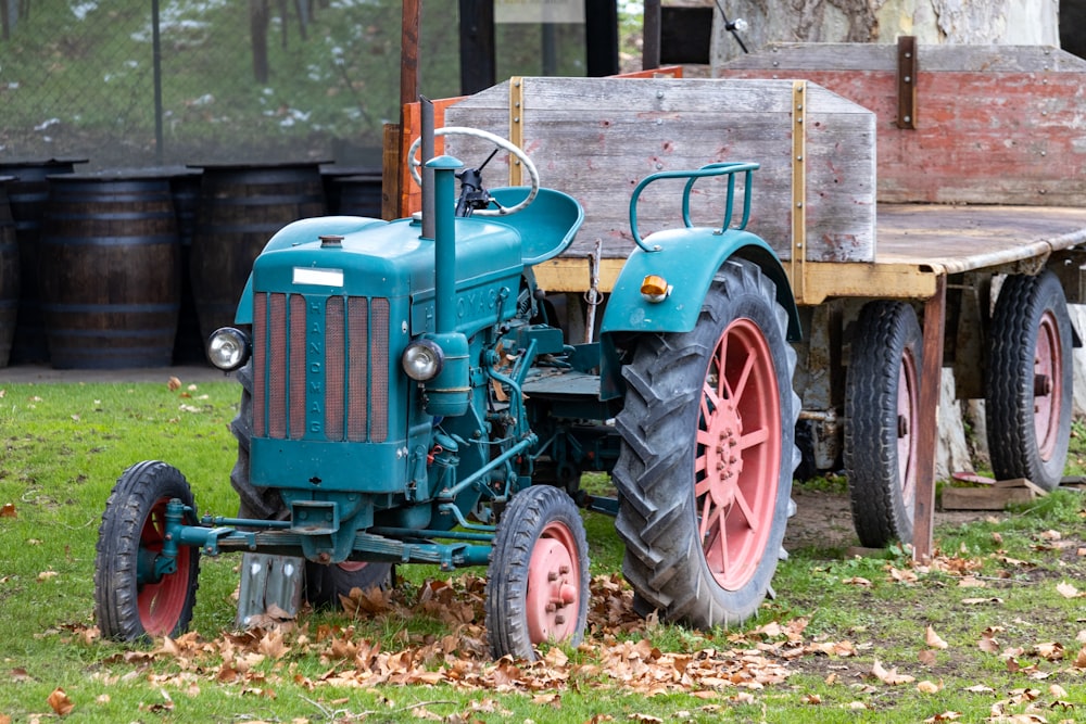 a blue tractor parked next to a wooden trailer