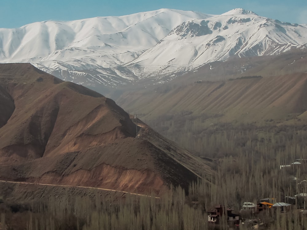 a snowy mountain range with a village in the foreground