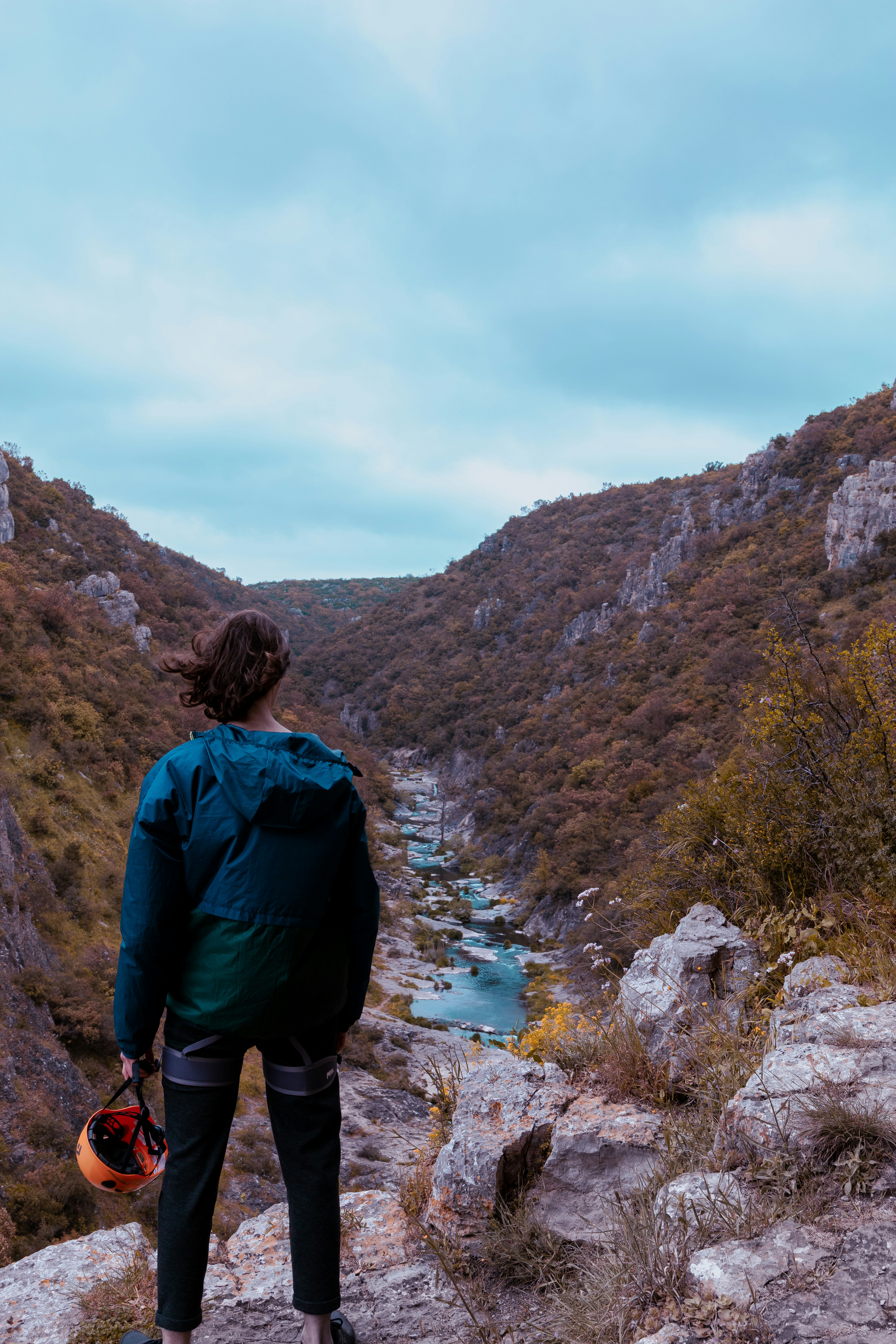 a person standing on a rock looking at a river