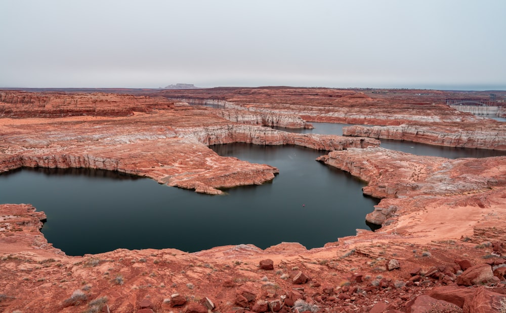 a large body of water surrounded by red rocks