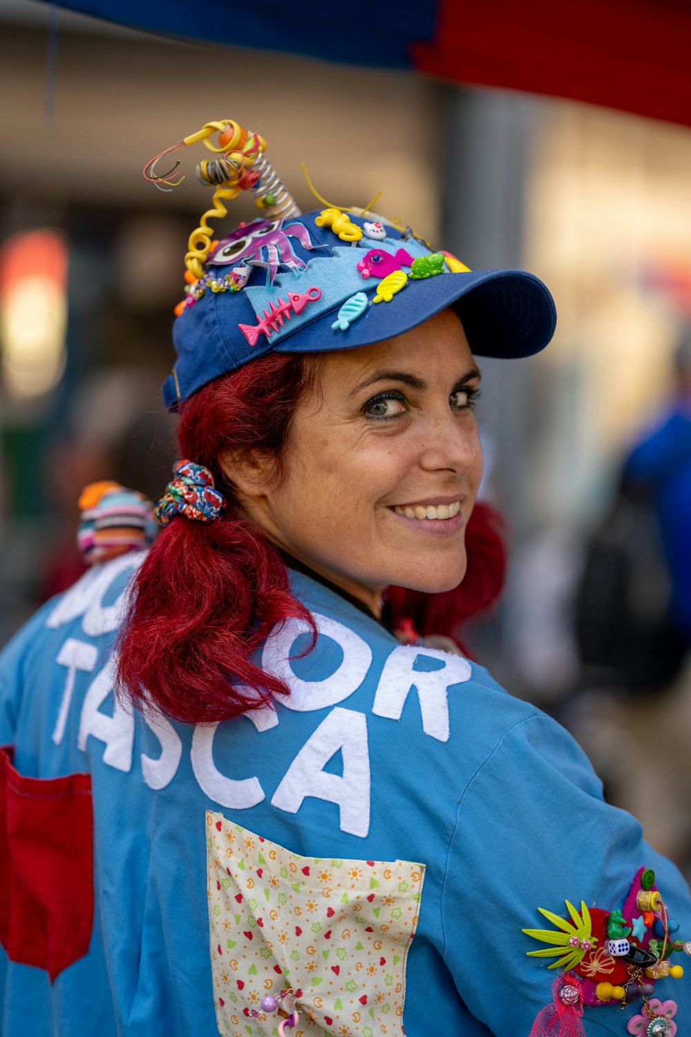 a woman with red hair wearing a blue hat