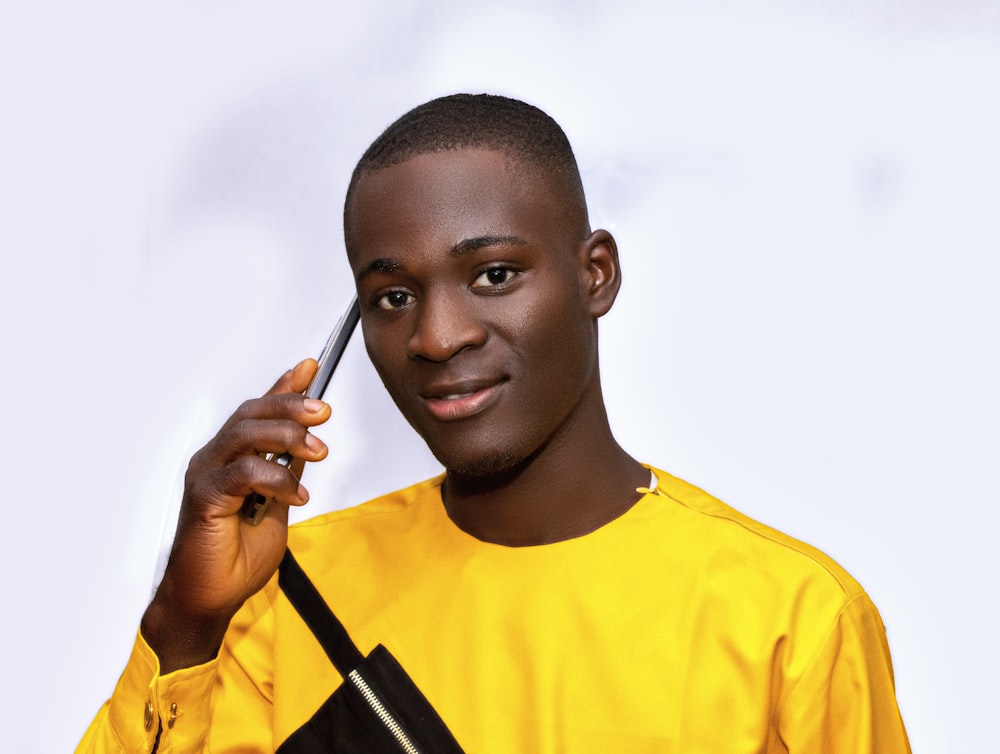 Un joven sosteniendo un teléfono celular en su oreja