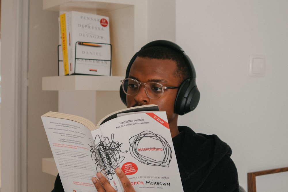 a man wearing headphones and reading a book