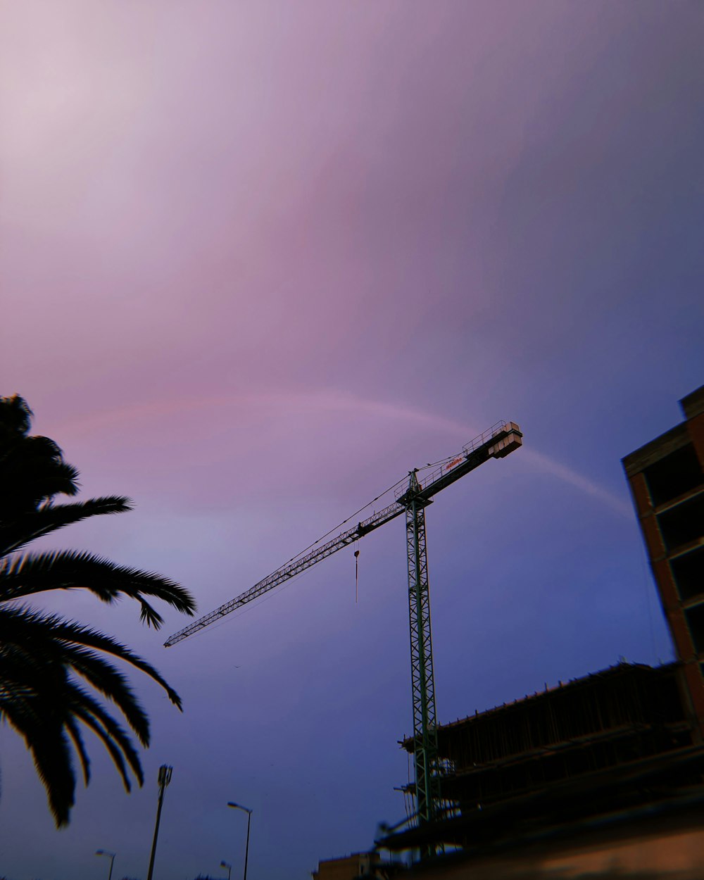 a crane and a building under a cloudy sky