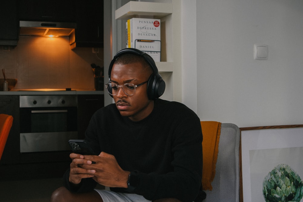 a man sitting in a chair looking at his cell phone