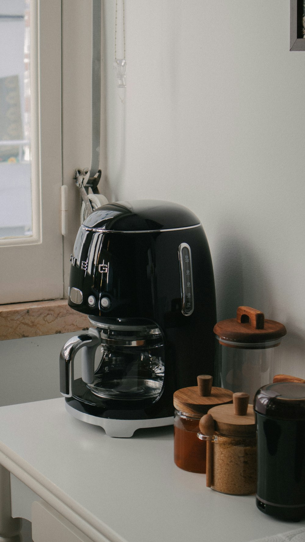 a black coffee maker sitting on top of a white counter