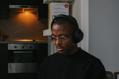 A focused young boy practicing Quran recitation with headphones in a cozy home setting.