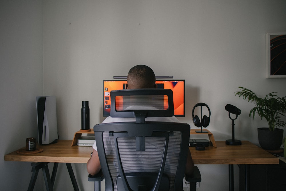 a man sitting in front of a computer monitor