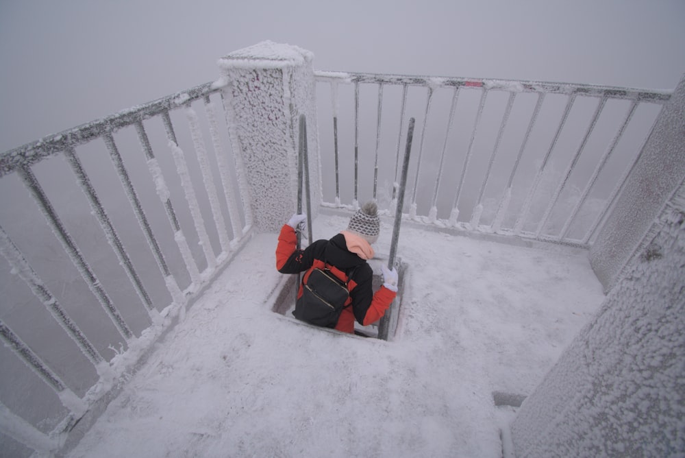 a person sitting on a bench covered in snow