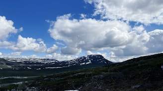 a view of a mountain range with snow on the ground