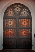 Close-up of a custom wrought iron door with intricate patterns and a rustic finish.