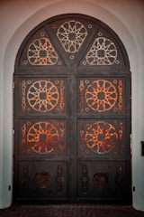 Elegant iron doors featuring geometric patterns and sturdy hinges.