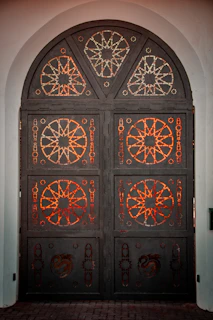 Finished sturdy iron door with intricate patterns standing proudly in a workshop