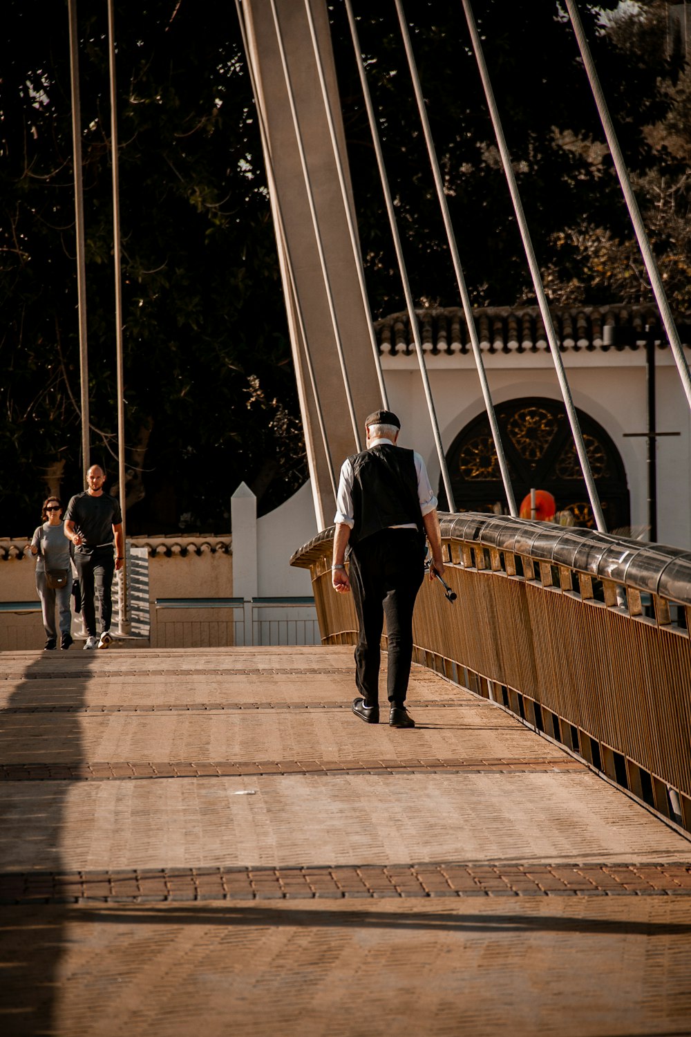 a man walking across a bridge over a river