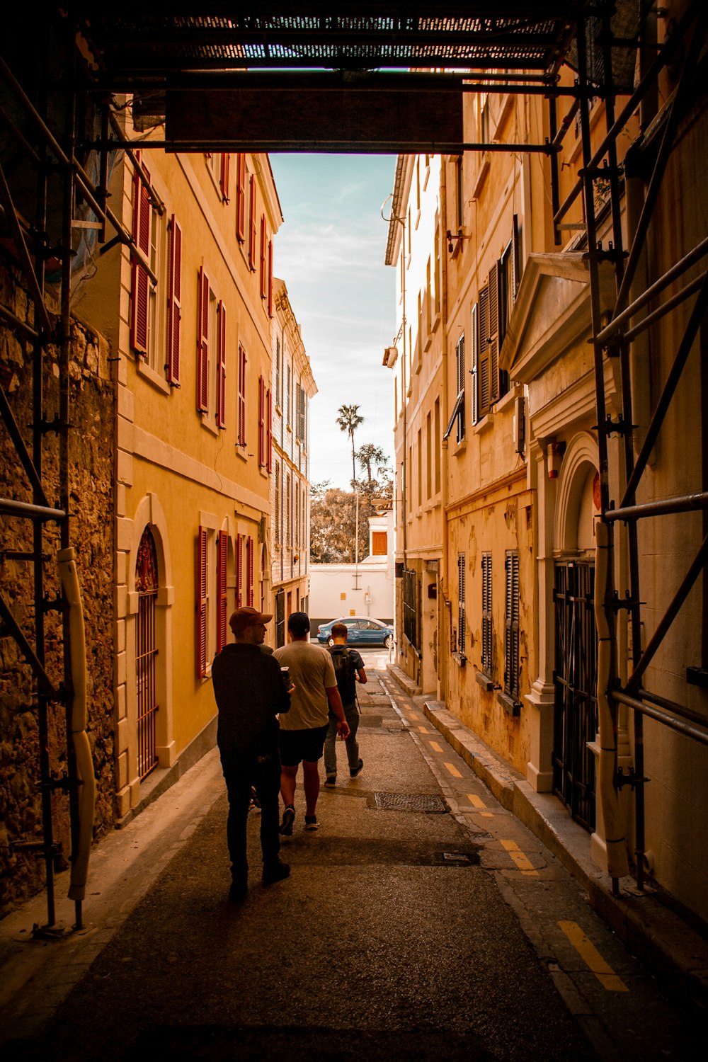 a group of people walking down a narrow street